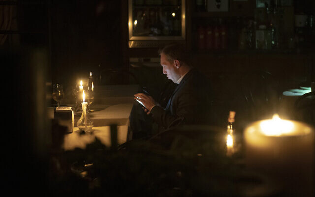 A man sits in a caffe during a blackout in Kyiv, Ukraine, Friday, Nov. 4, 2022. (AP Photo/Andrew Kravchenko)