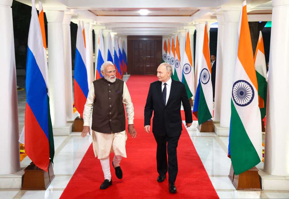 In this pool photograph distributed by the Russian state agency Sputnik, Russia's President Vladimir Putin and Indian Prime Minister Narendra Modi walk prior to an informal dinner at Modi's residence in New Delhi on December 4, 2025, the first day of the Russian leader's two-day state visit to India. (Photo by Alexander KAZAKOV / POOL / AFP)