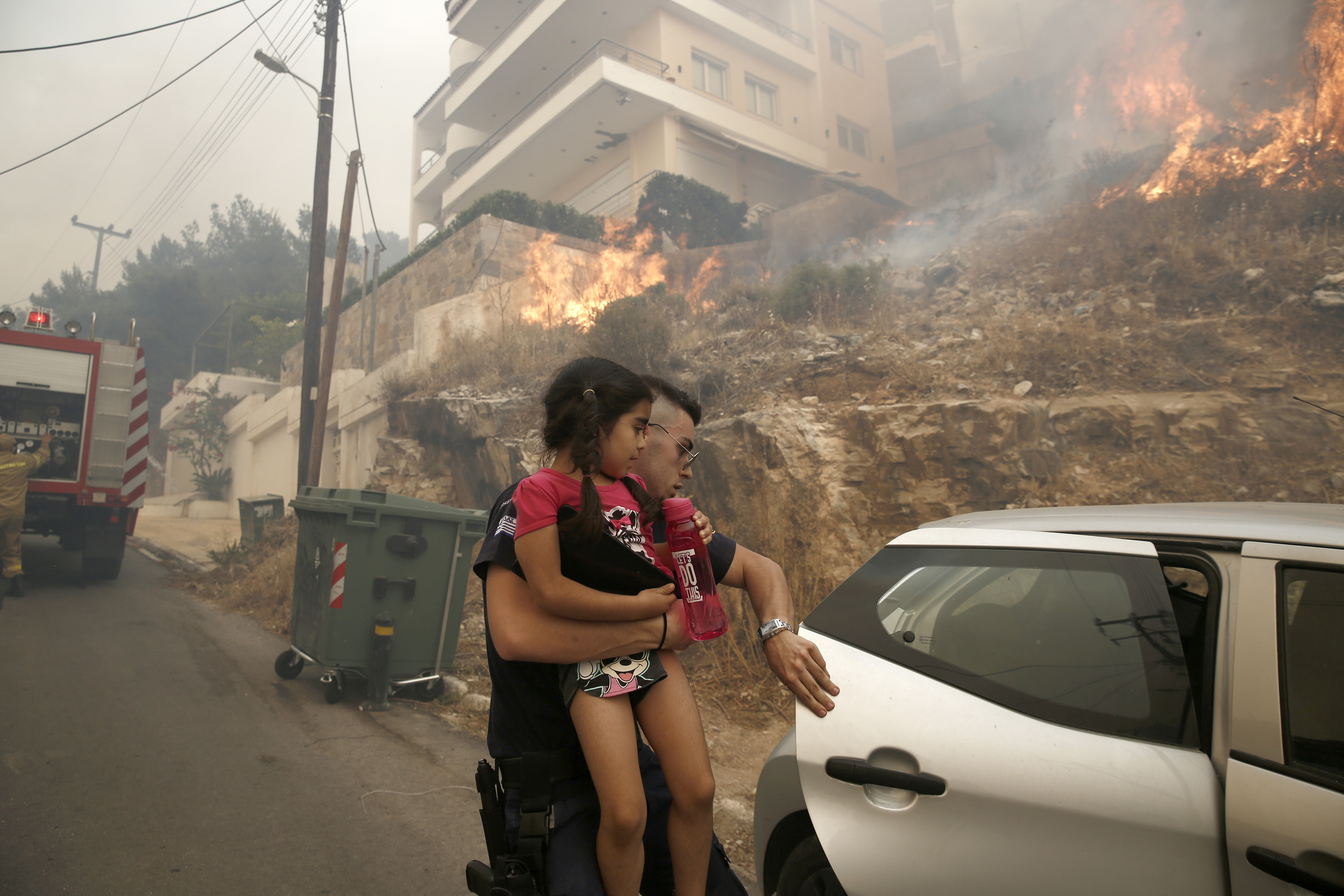 Άνδρας με κοριτσάκι στην αγκαλιά του απομακρύνεται από την περιοχή της πυρκαγιάς που καίει μέσα σε κατοικημένη περιοχή στην Άνω Βούλα, Σάββατο 4 Ιουνίου 2022. Προς τη Βούλα έχει κινηθεί η φωτιά, που ξέσπασε νωρίτερα σε περιοχή της Άνω Γλυφάδας. Κι εκεί πλέον αρχίζει να απειλείται κατοικημένη περιοχή. Μάλιστα ο δήμαρχος Βάρης-Βούλας-Βουλιαγμένης Γρηγόρης Κωνσταντέλλος ζήτησε να γίνει εκκένωση της περιοχής Πανόραμα, από την οδό Υμηττού και προς τον ορεινό όγκο και οι κάτοικοι να συνεργαστούν με τις Αρχές. ΑΠΕ-ΜΠΕ/ΑΠΕ-ΜΠΕ/ΓΙΑΝΝΗΣ ΚΟΛΕΣΙΔΗΣ